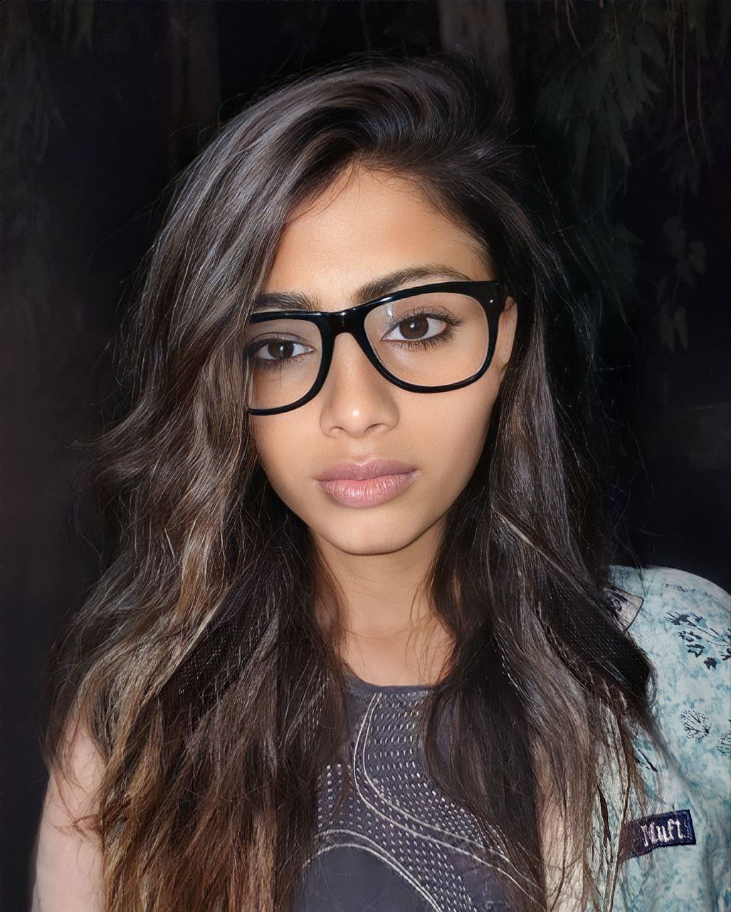 a woman with long hair and glasses